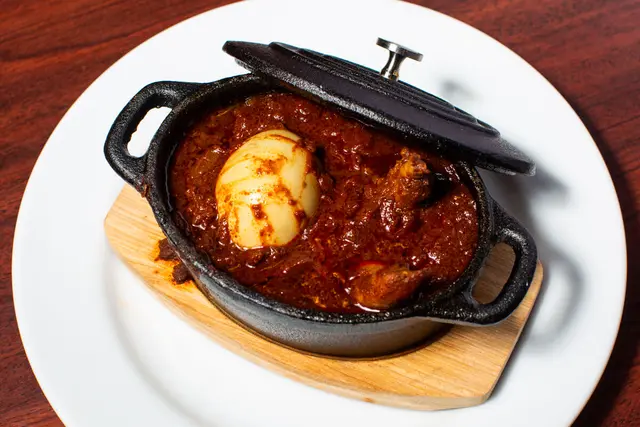 Doro wat at Gojo Ethiopian Restaurant Winnipeg — spicy berbere chicken stew with hard-boiled egg on injera